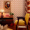 Roomset close-up of vintage, diamond geometric wallpaper in vintage pink and harvest gold colourway