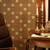 Roomset close-up of 70s geometric wallpaper in earthy orange, chocolate and harvest gold colourway
