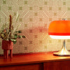 Roomset close-up of 70s geometric wallpaper in vanilla, butterscotch and olive green colourway